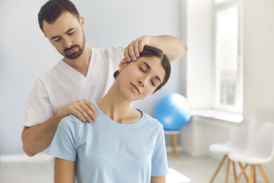 Licensed chiropractor doing neck adjustment to a female patient